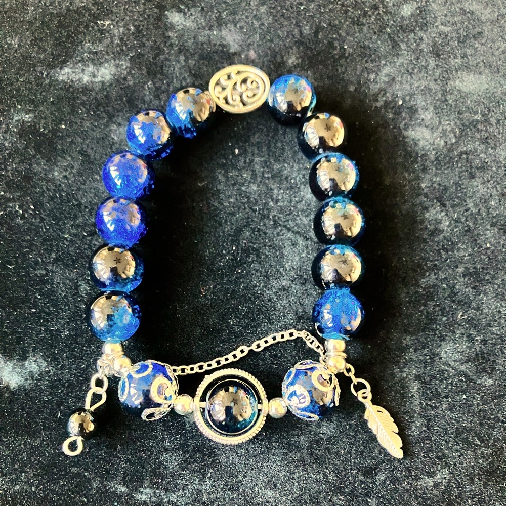 Blue and silver glass bead bracelet with a touch of goth charm 
8cm/3.14in